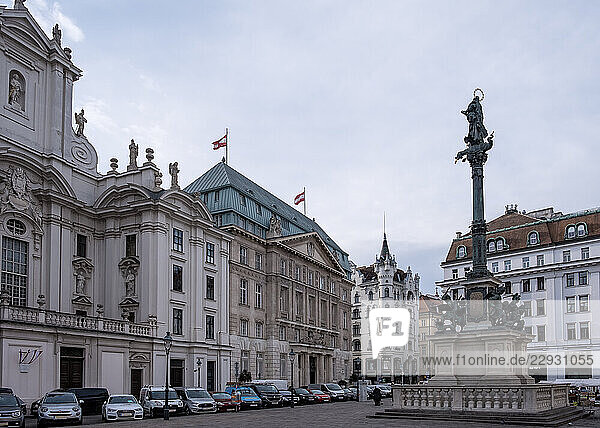 Vienna  Austria dz?dz?dz? View of the Mariensvdz?ule  the 17th-century plague column standing before the Kirche am Hof  its gilded Virgin Mary statue contrasting with the church s stark Gothic facade on Am Hof square.