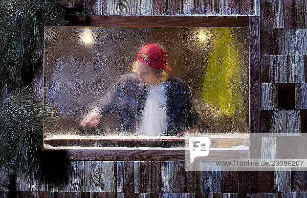 A snowboarder waxing his snowboard