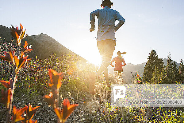 A couple trail running at sunset.