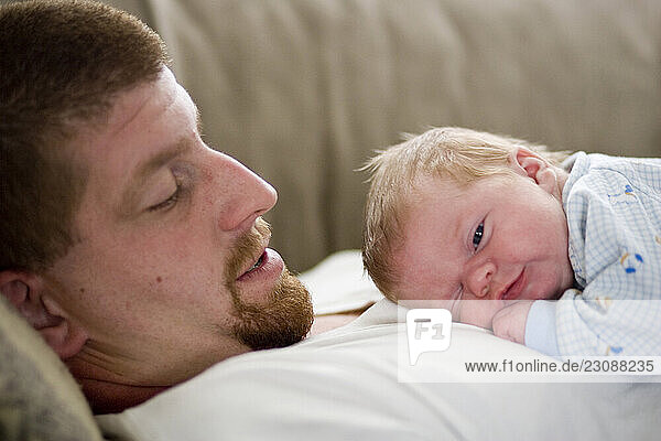 A infant boy and his father bonding.